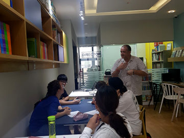 teacher instructing students in Library at Leaders Academy