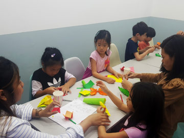 teachers helping students with crafts