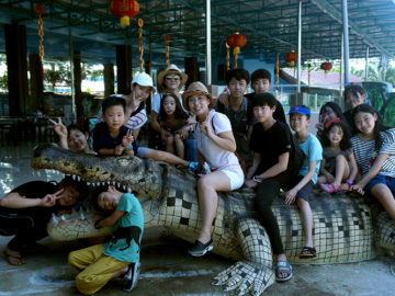 camp kids posing on an alligator