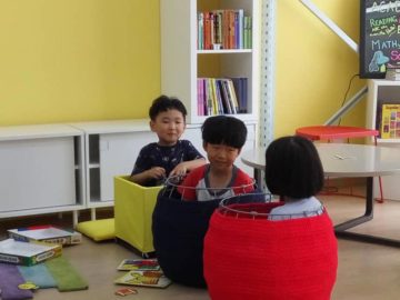 Three students playing in ground floor library