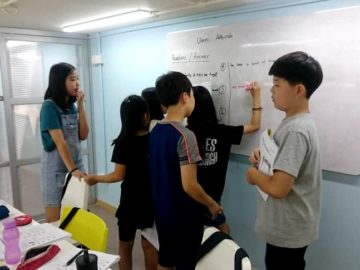 Students helping each other on whiteboard
