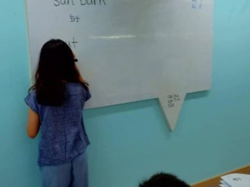 Student writing on whiteboard