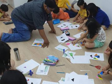 Teacher helping students with Math craft